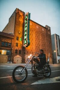 man riding on cruiser motorcycle near Alabama LED signage